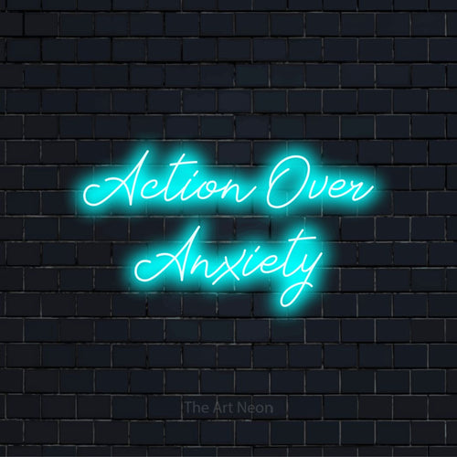 "Action Over Anxiety" LED neon sign on a black brick wall