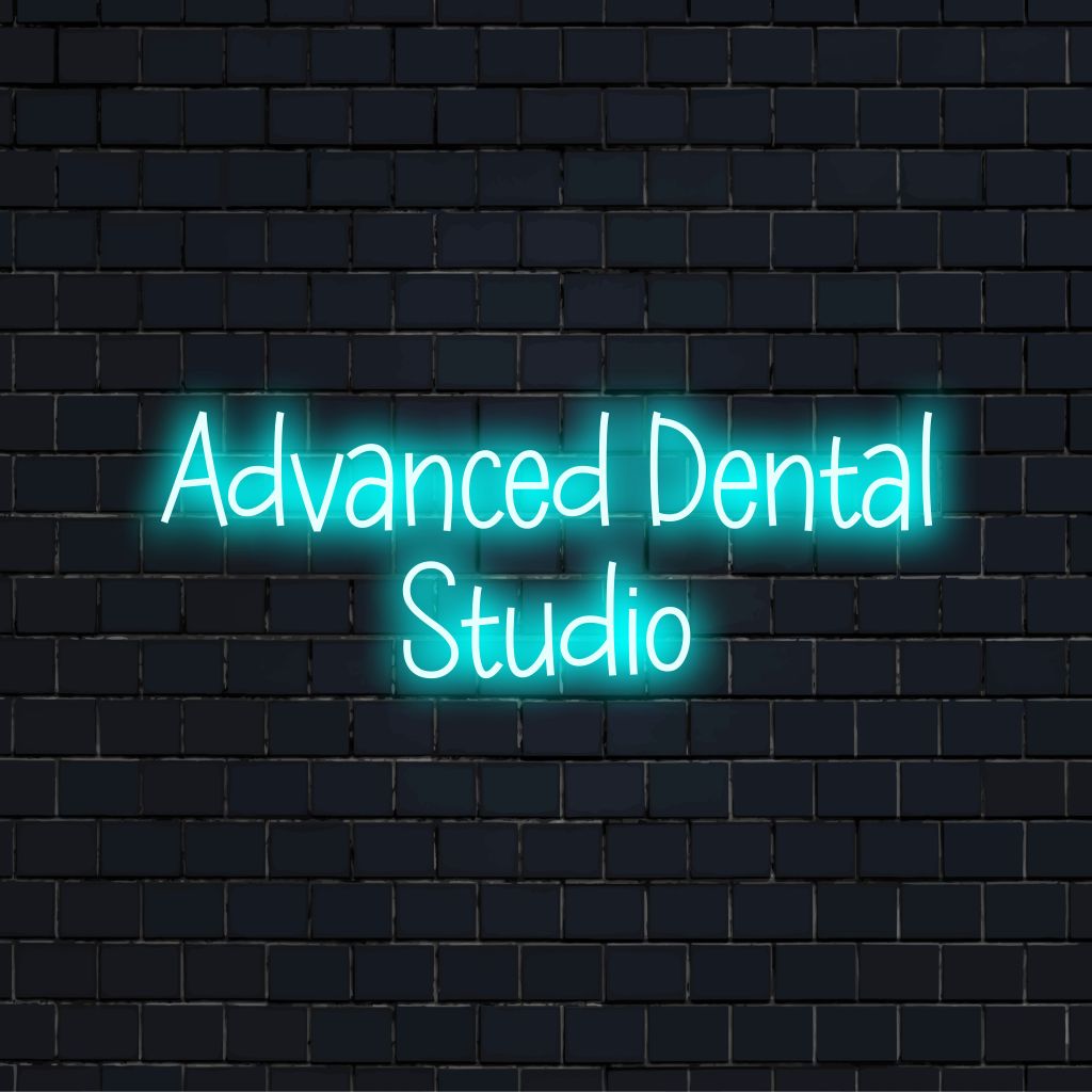 Advanced Dental Studio LED Neon Sign, bright neon lettering on black brick background