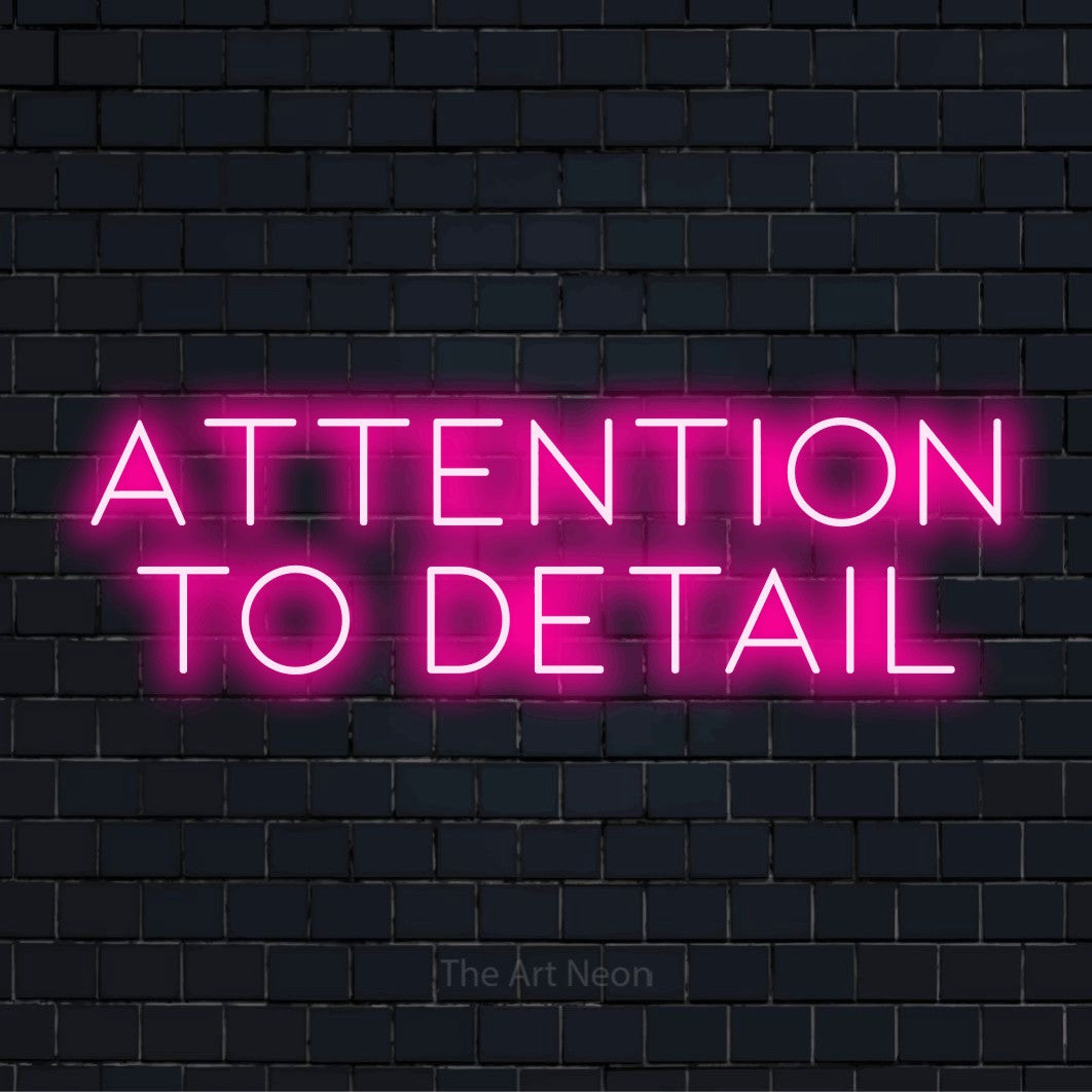 "Attention To Detail" glowing LED neon sign on a black brick wall