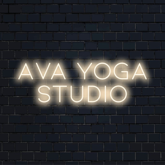 Ava Yoga Studio Personalized Neon Light with glowing neon text on dark brick wall