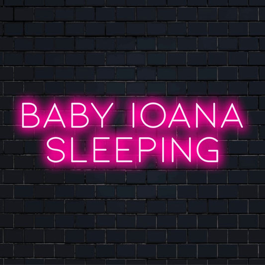 Baby Ioana Sleeping Personalized LED Neon Sign, bright neon glow on dark brick wall