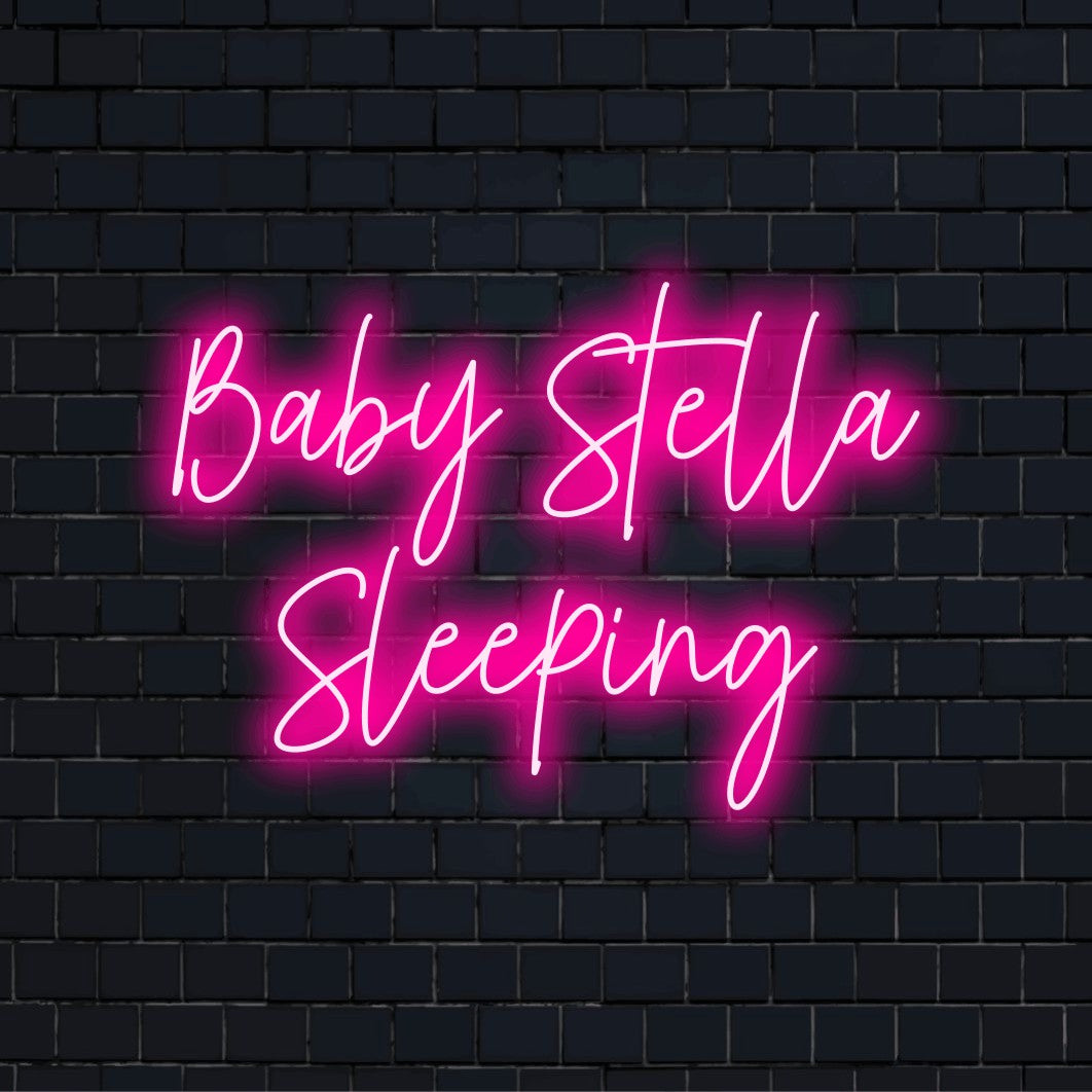 Baby Stella Sleeping Custom Name Neon Sign, neon text light on dark brick wall