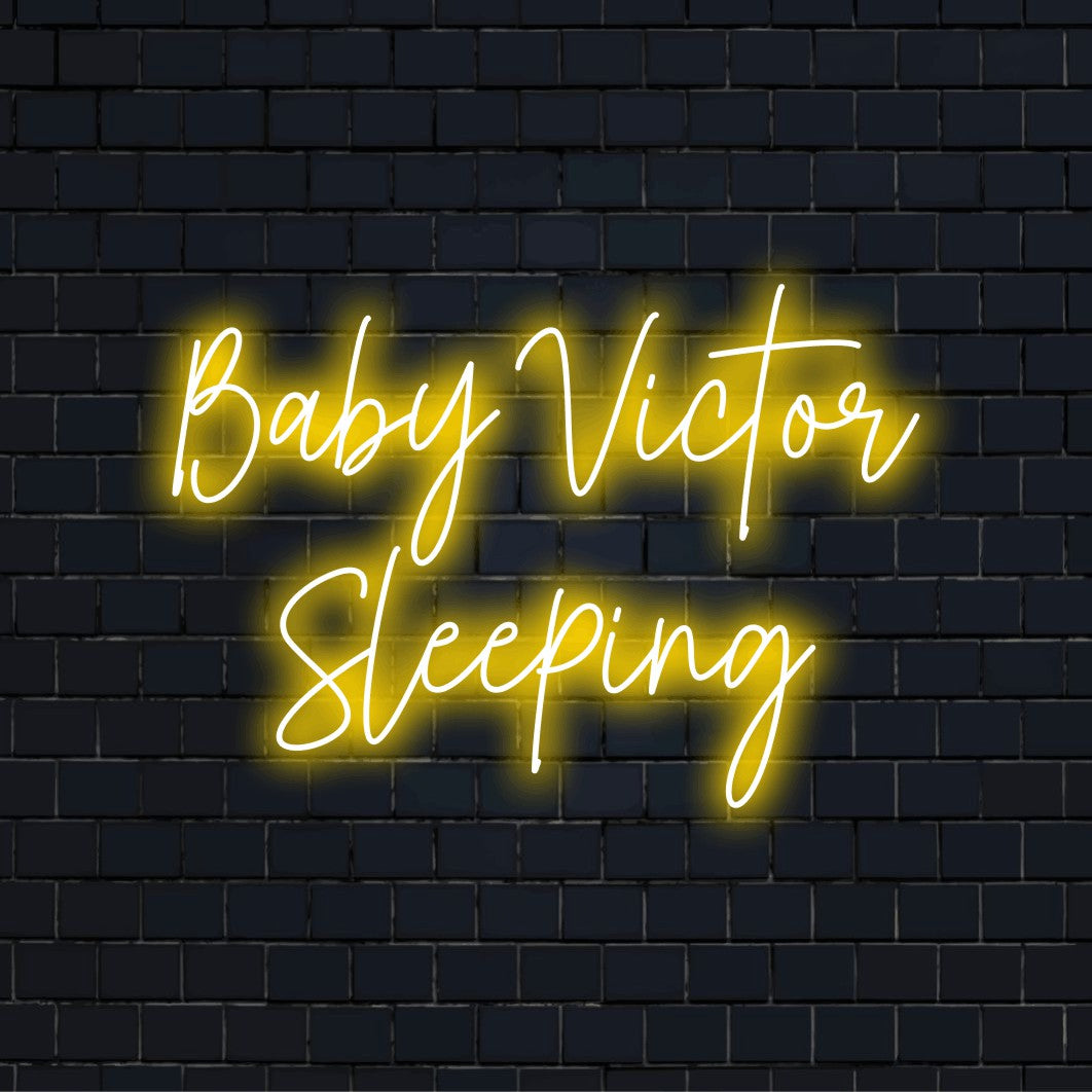Baby Victor Sleeping Personalized LED Neon Sign, bright neon lettering on dark brick wall