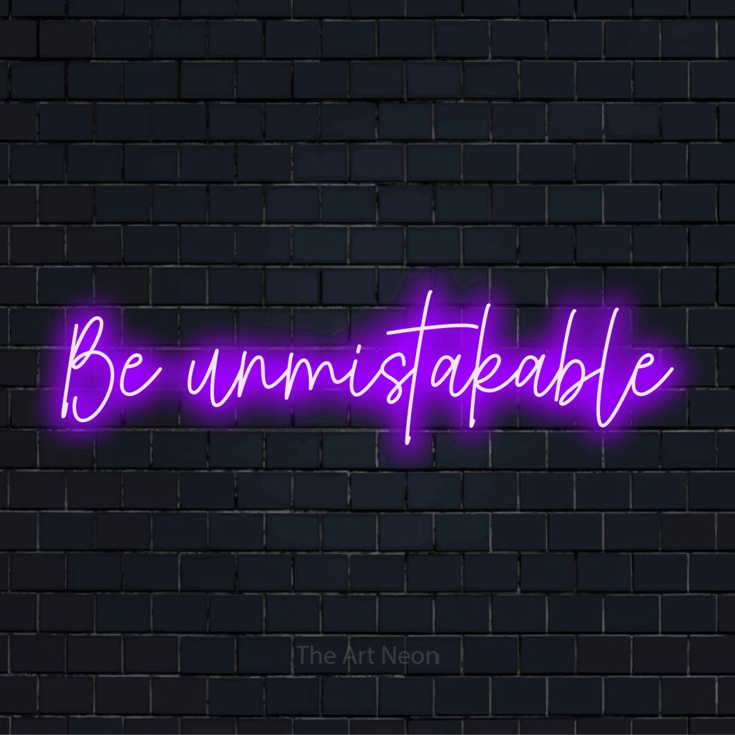 "Be Unmistakable" LED neon sign on a black brick wall