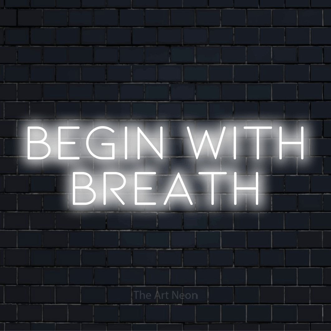 "Begin With Breath" neon text design on a black brick wall