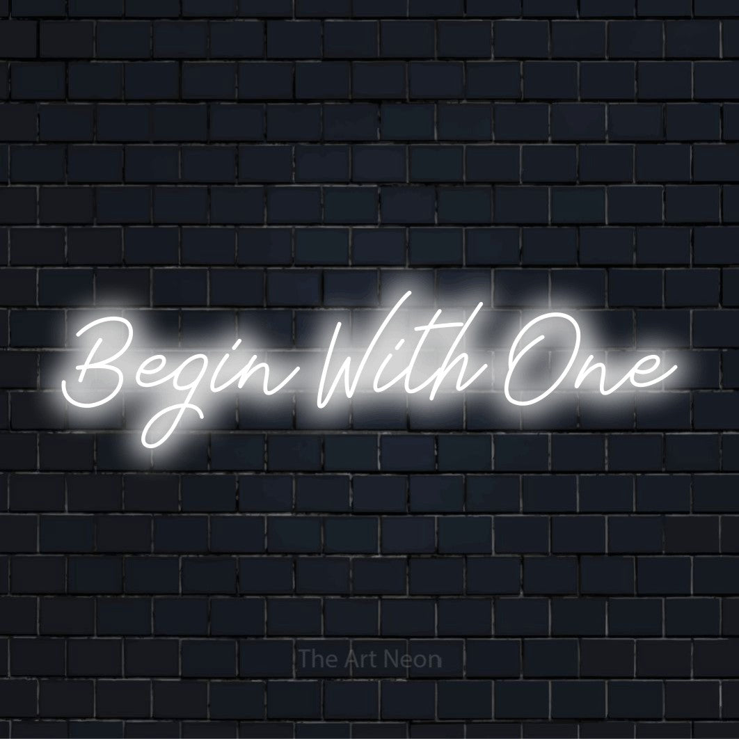 "Begin With One" glowing LED neon sign on a black brick wall