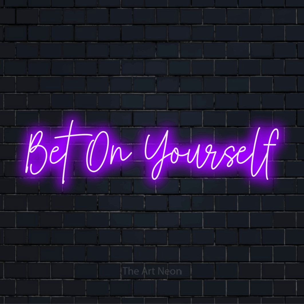 "Bet On Yourself" glowing LED neon sign on a black brick wall
