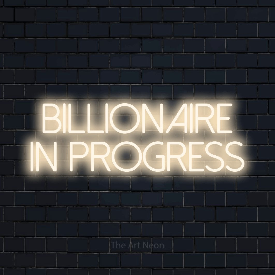 "Billionaire In Progress" glowing LED neon sign on a black brick wall