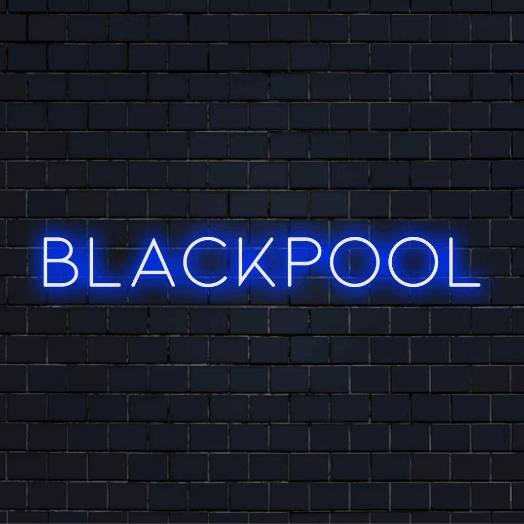 Blackpool Neon Light with glowing lettering on dark brick background