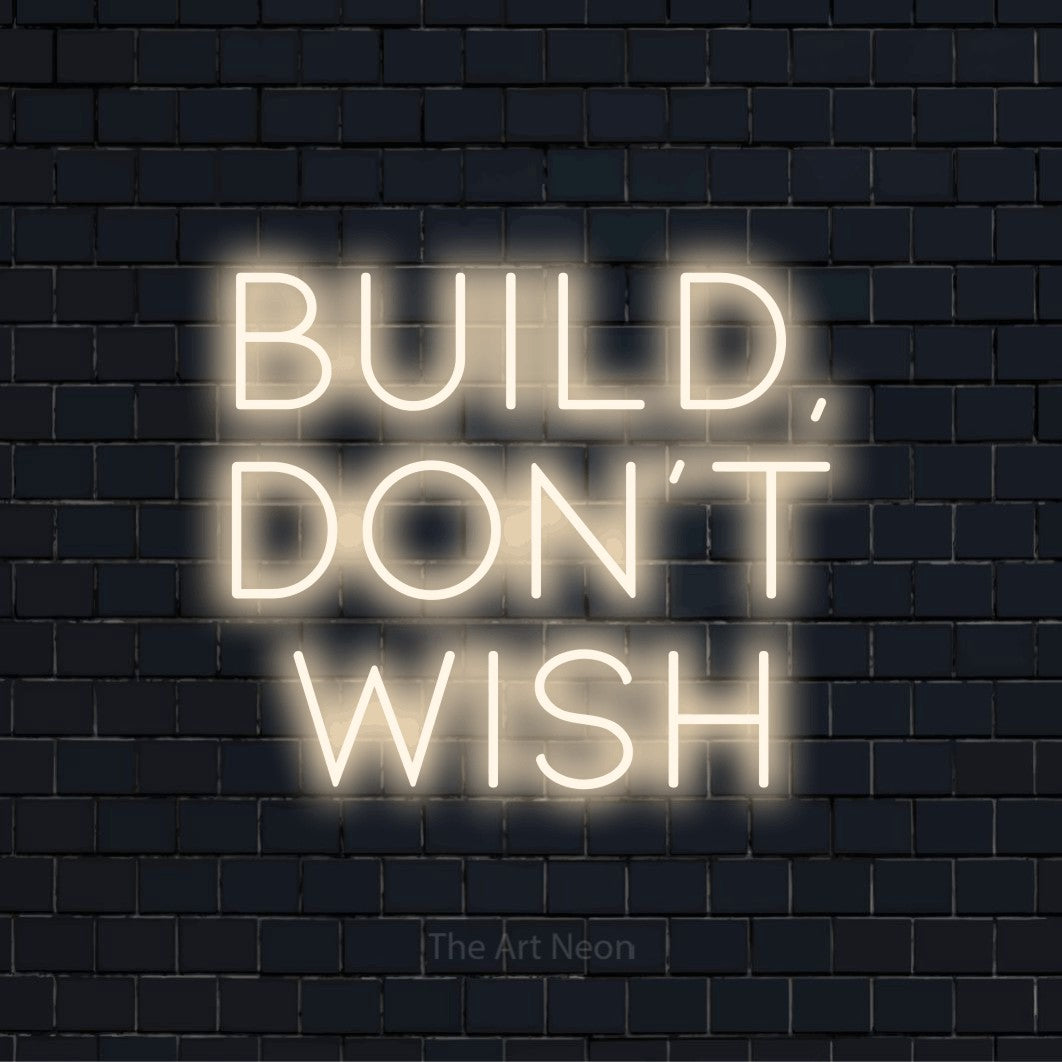 "Build, Don’t Wish" LED neon sign on a black brick wall