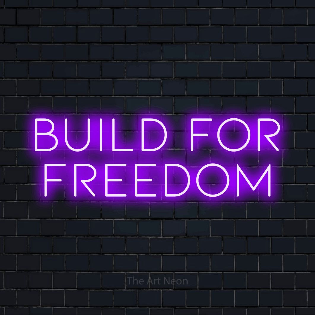 "Build For Freedom" neon text design on a black brick wall