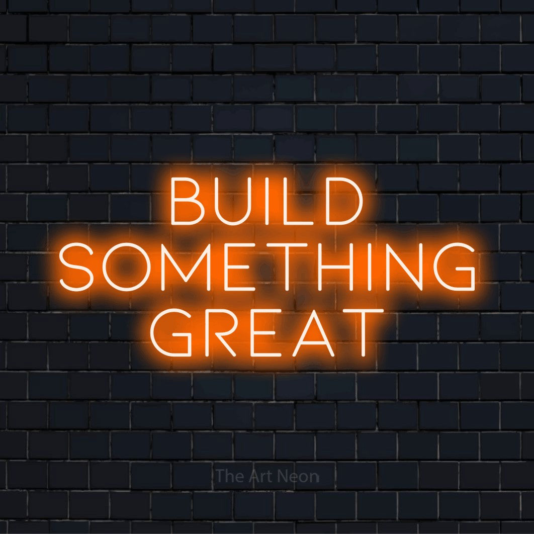 "Build Something Great" script-style LED neon sign on a black brick wall