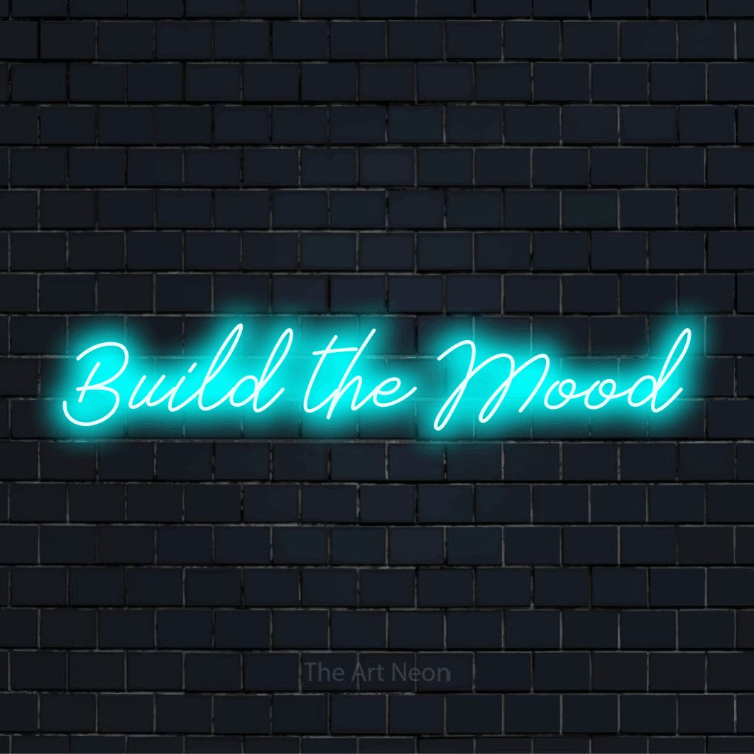 "Build The Mood" neon text design on a black brick wall