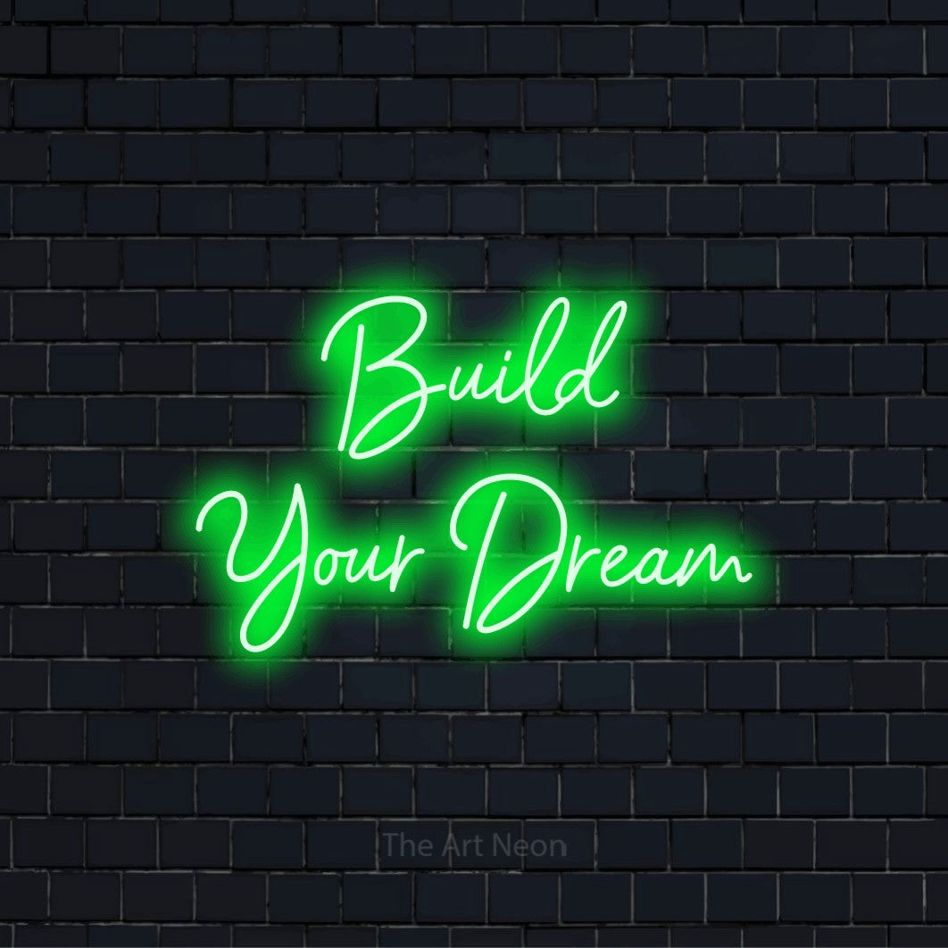 "Build Your Dream" text design with neon effect on a black brick wall