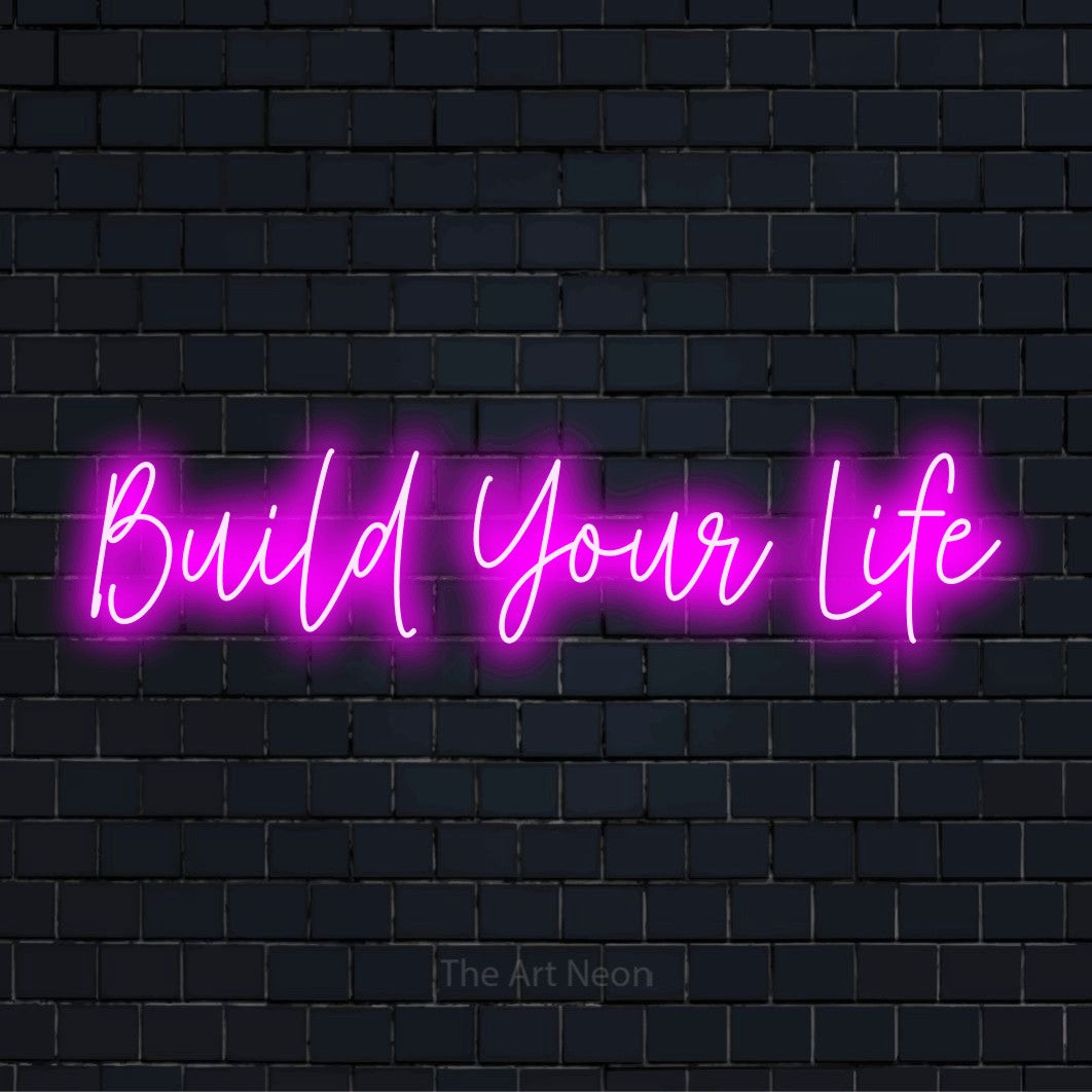"Build Your Life" neon text design on a black brick wall