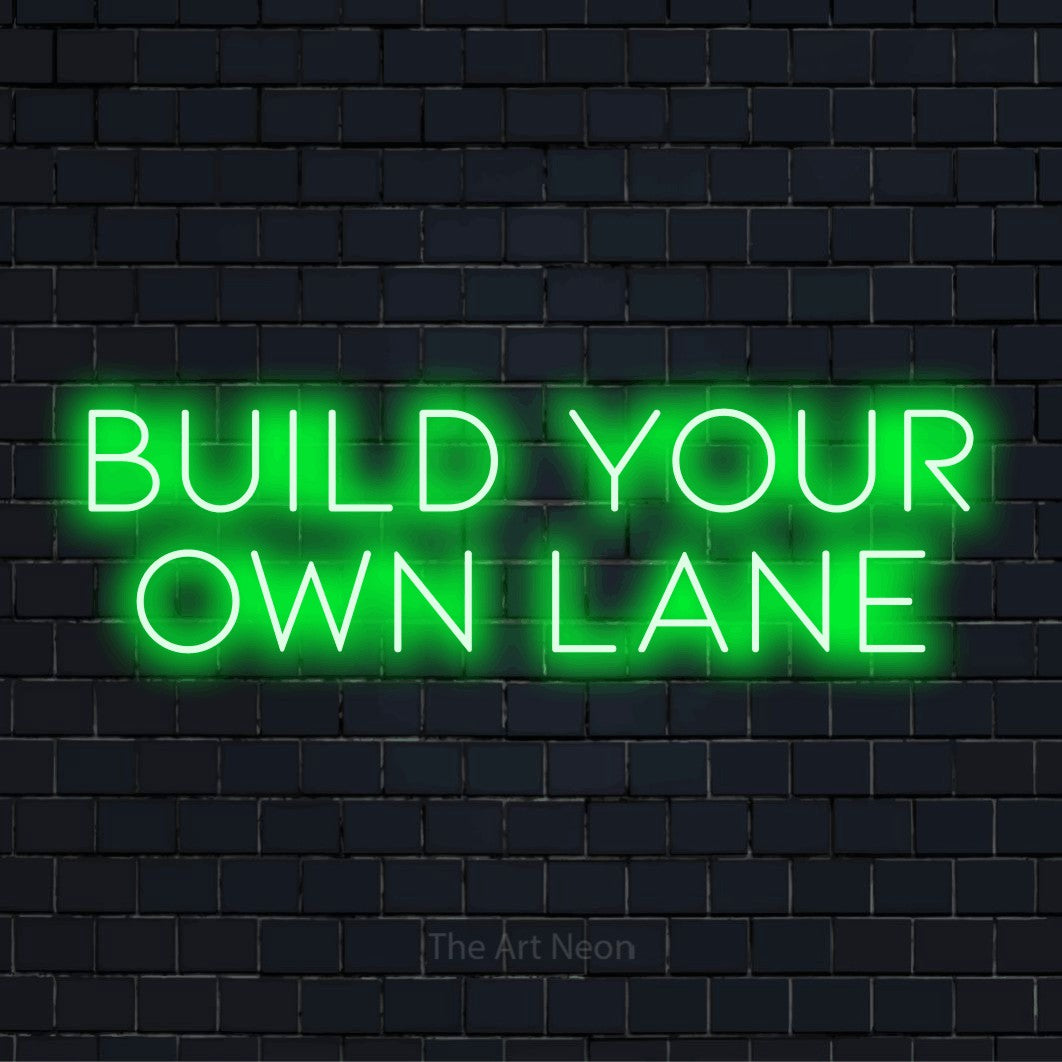 "Build Your Own Lane" LED neon sign on a black brick wall