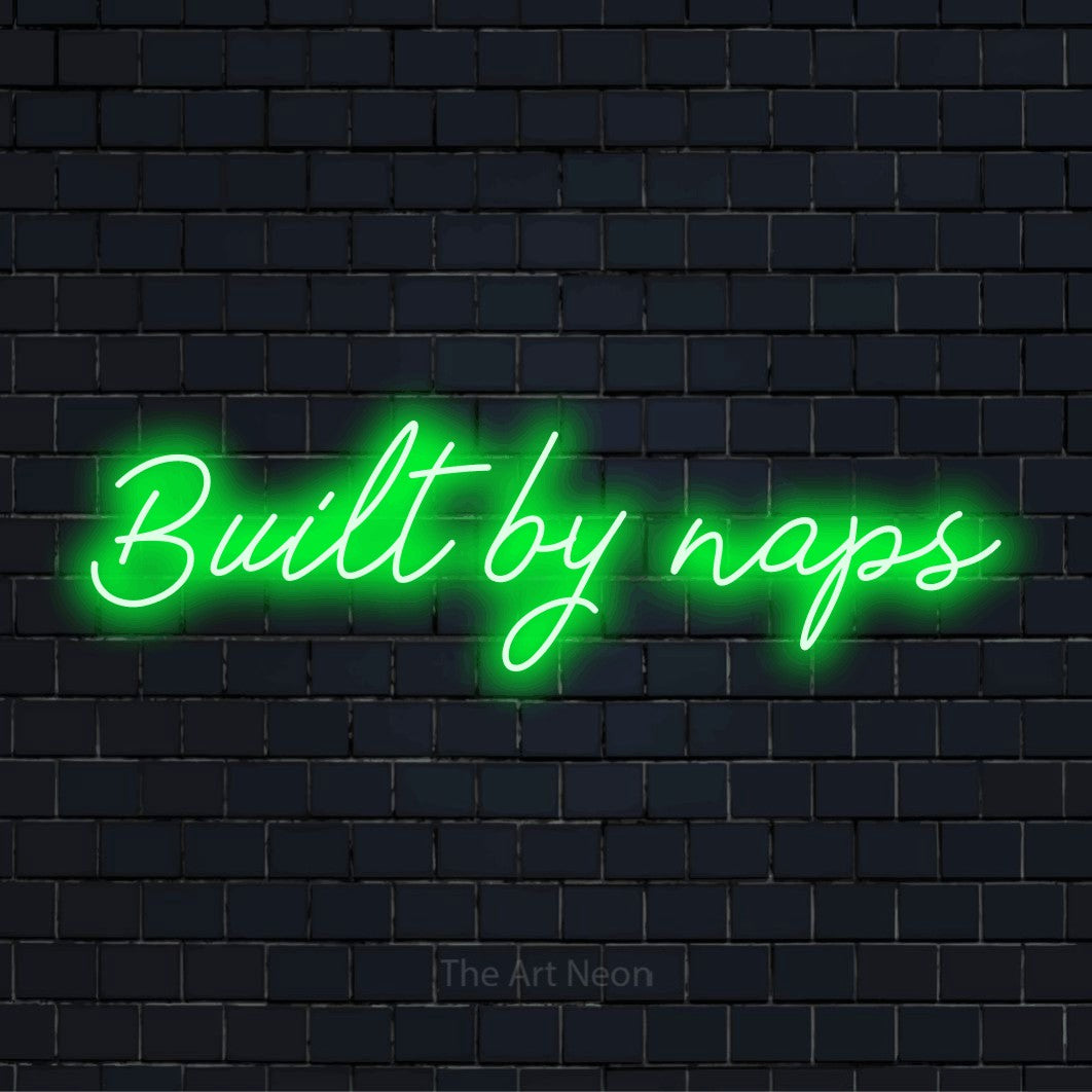 "Built By Naps" glowing LED neon sign on a black brick wall