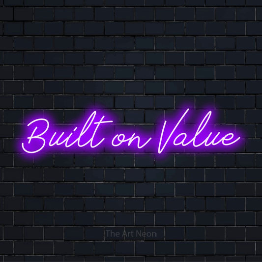 "Built On Value" text design with neon effect on a black brick wall