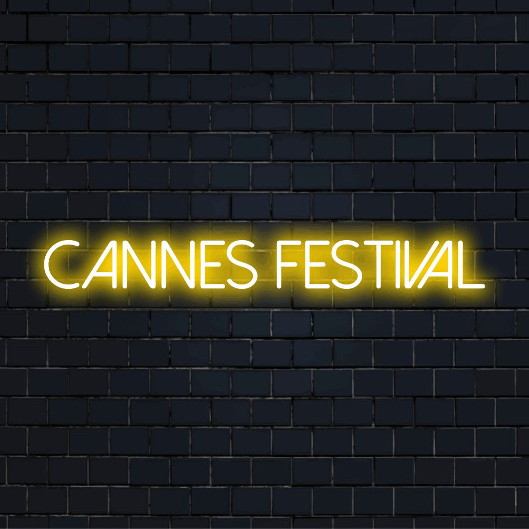 Cannes Festival Neon Light with glowing lettering on dark brick wall