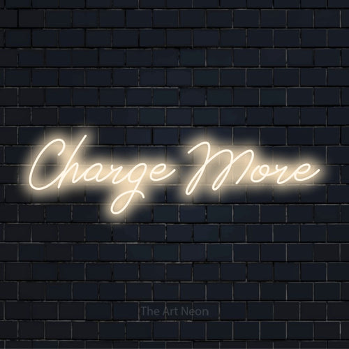 "Charge More" glowing LED neon sign on a black brick wall