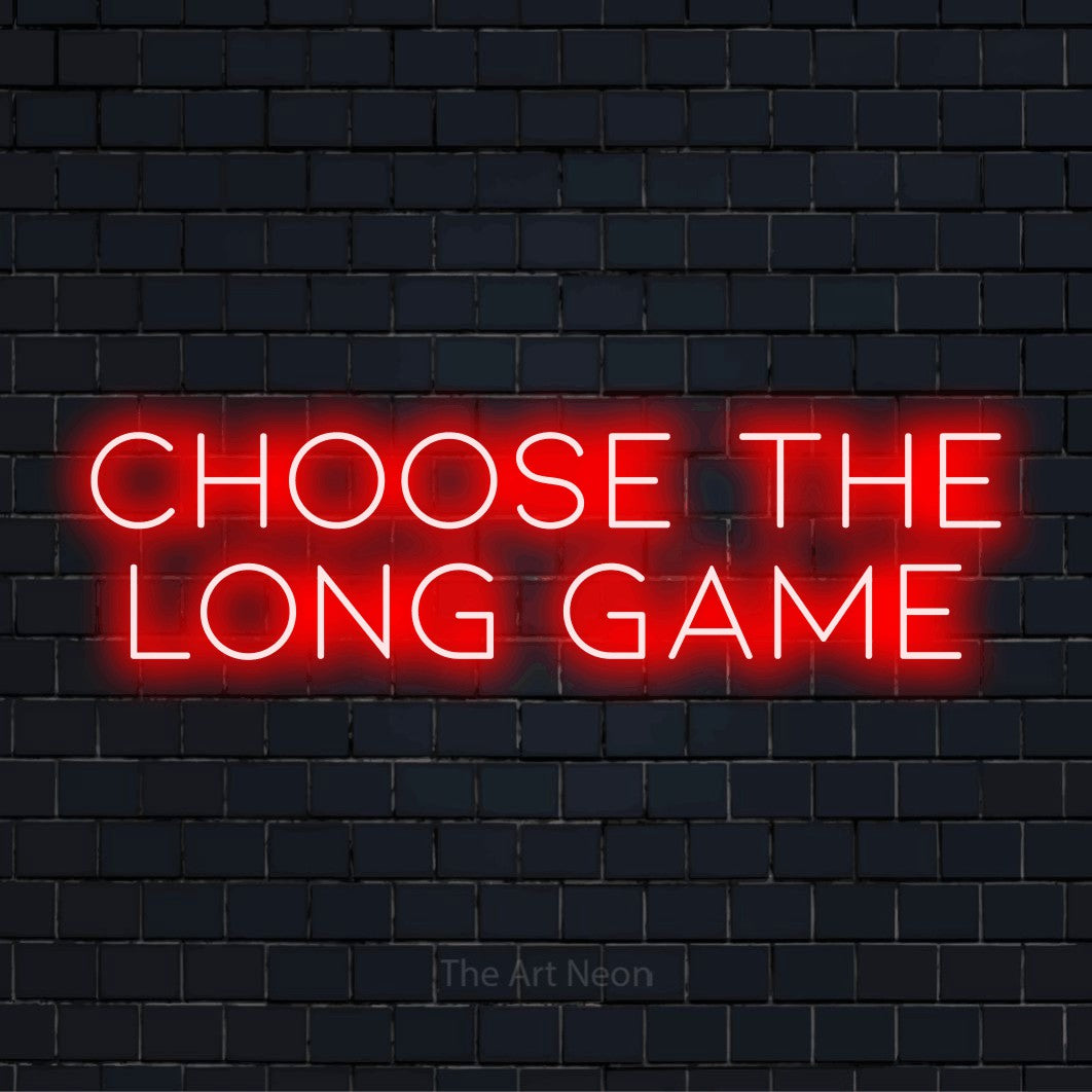 "Choose The Long Game" neon text design on a black brick wall
