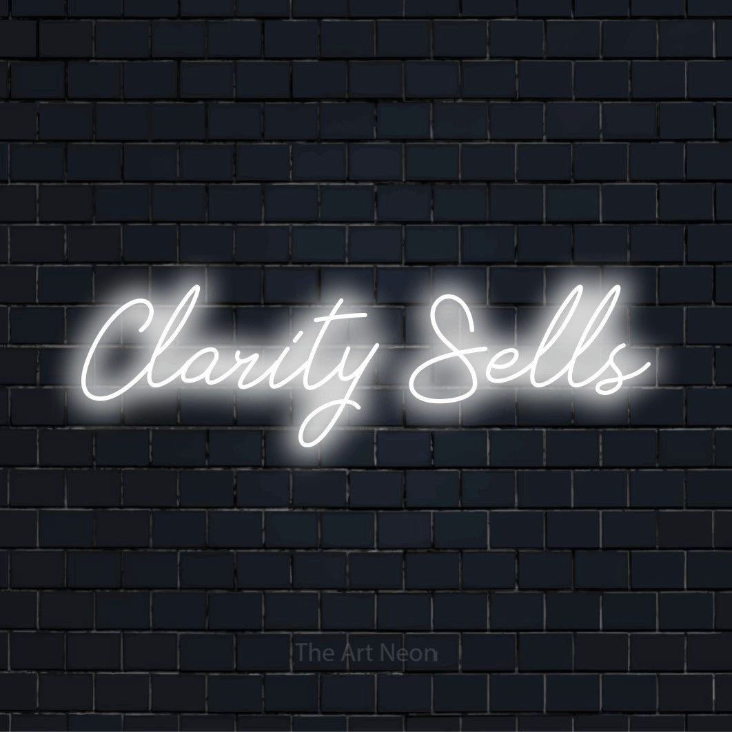 "Clarity Sells" neon text design on a black brick wall