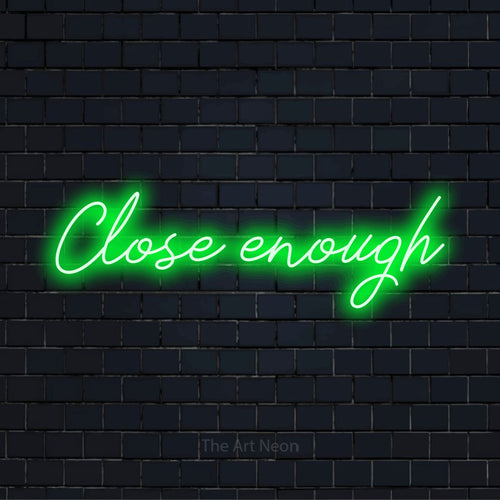 "Close Enough" glowing LED neon sign on a black brick wall
