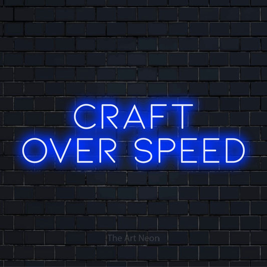 "Craft Over Speed" script-style LED neon sign on a black brick wall