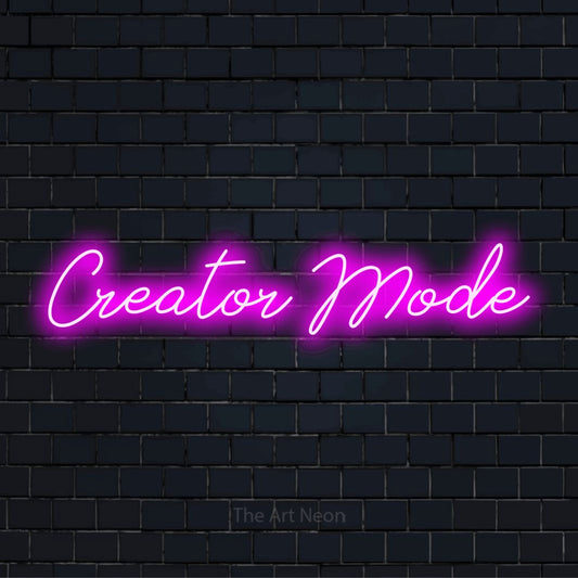"Creator Mode" script-style LED neon sign on a black brick wall