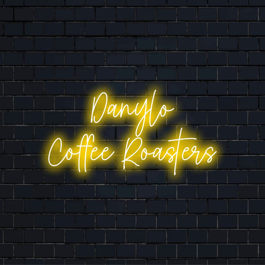 Danylo Coffee Roasters Custom Name Neon Sign, neon text light on dark brick background