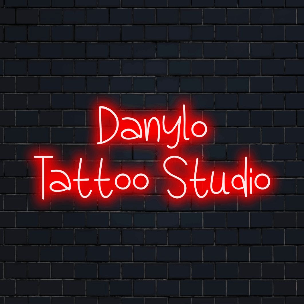 Danylo Tattoo Studio Personalized Neon Light with bright neon glow against black brick wall