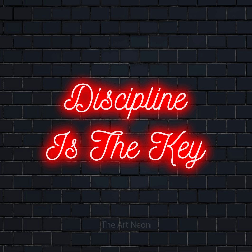 "Discipline Is The Key" script-style LED neon sign on a black brick wall