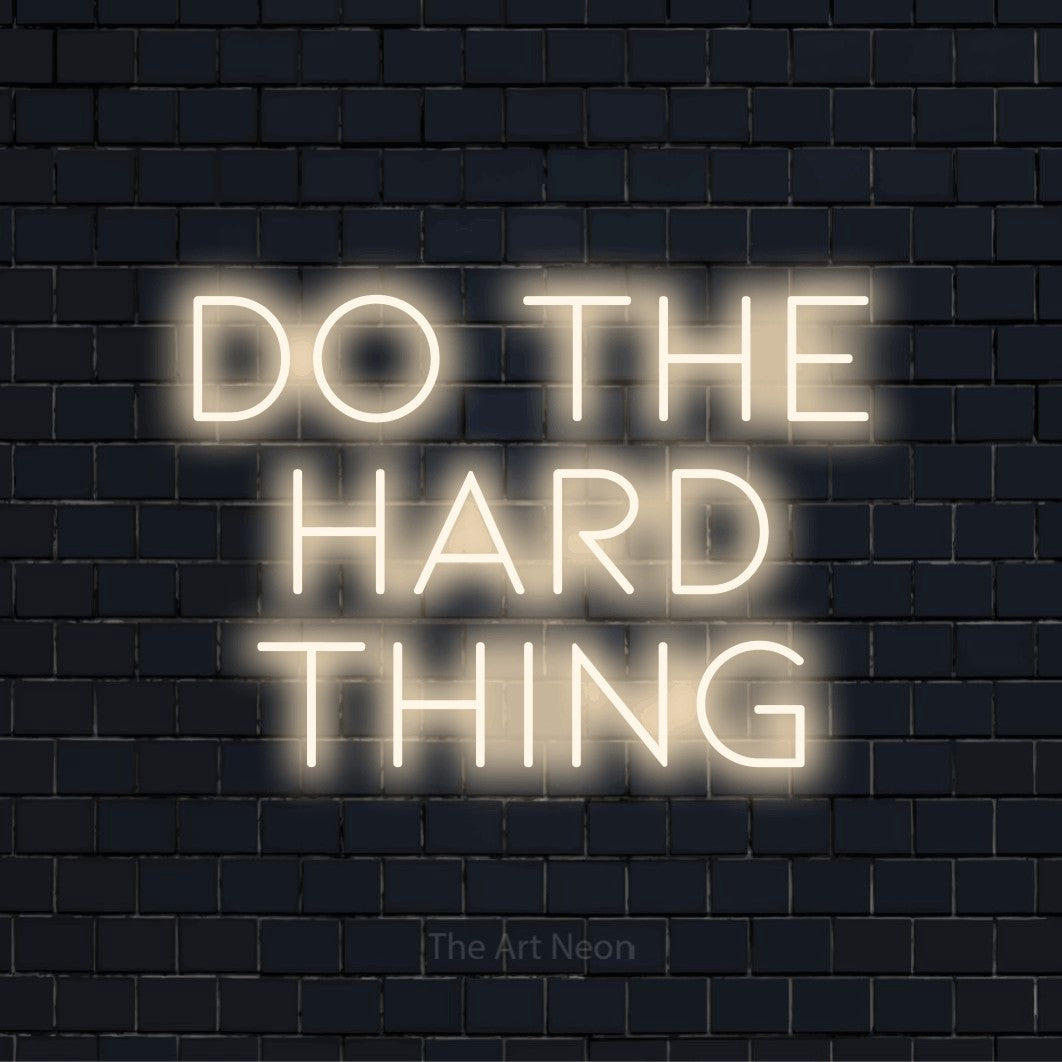 "Do The Hard Thing" text design with neon effect on a black brick wall
