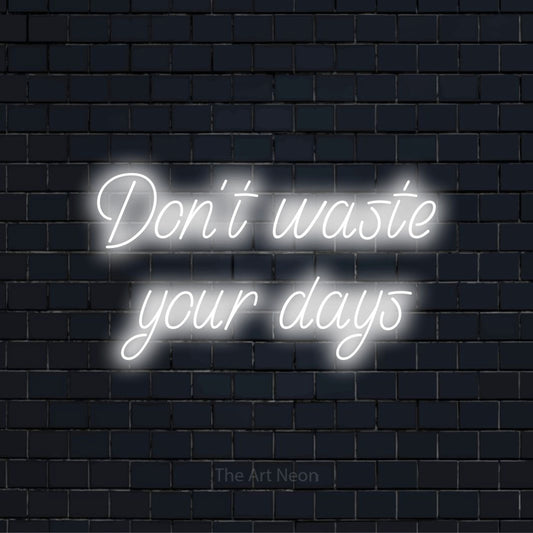 "Don’t Waste Your Days" script-style LED neon sign on a black brick wall