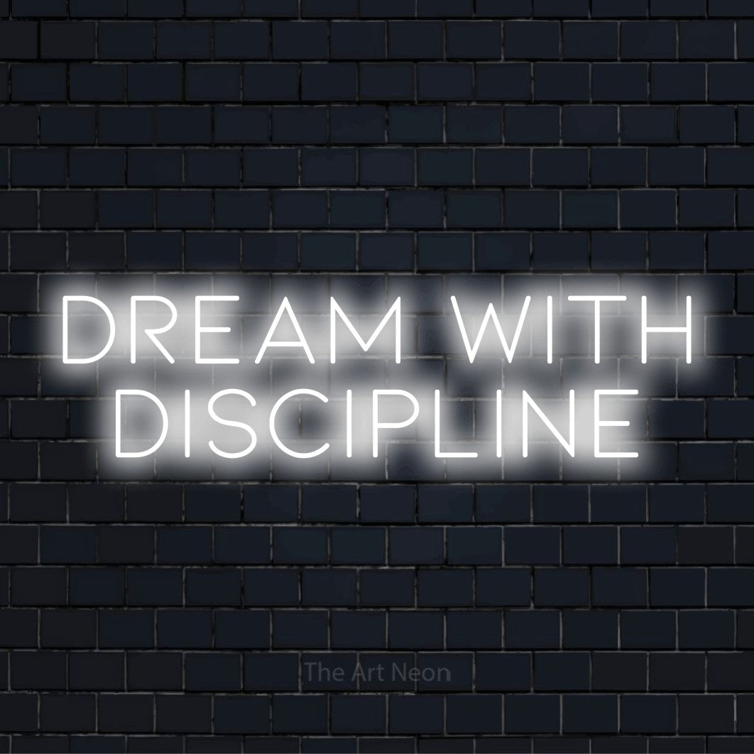 "Dream With Discipline" neon text design on a black brick wall