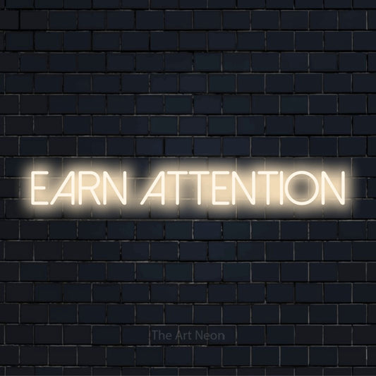 "Earn Attention" neon text design on a black brick wall