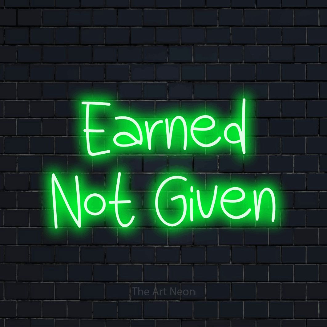 "Earned Not Given" neon text design on a black brick wall
