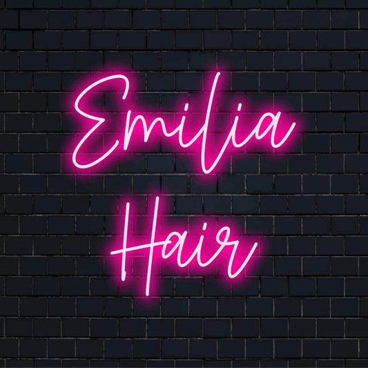 Emilia Hair Custom Name Neon Sign, glowing neon text against black brick wall