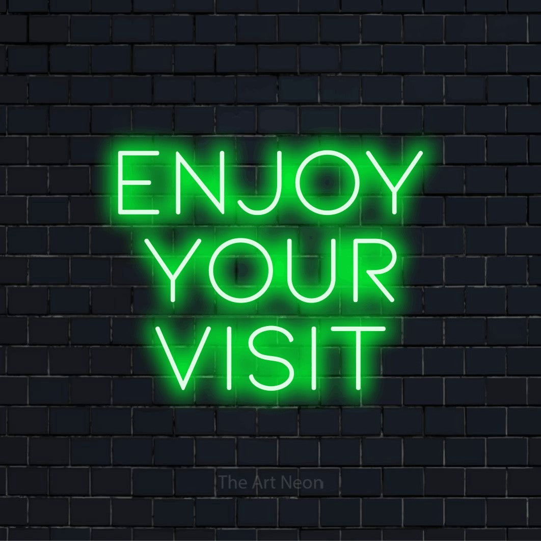 "Enjoy Your Visit" text design with neon effect on a black brick wall