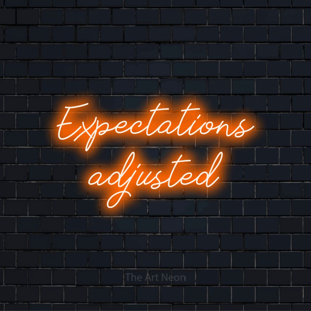 "Expectations Adjusted" LED neon sign on a black brick wall