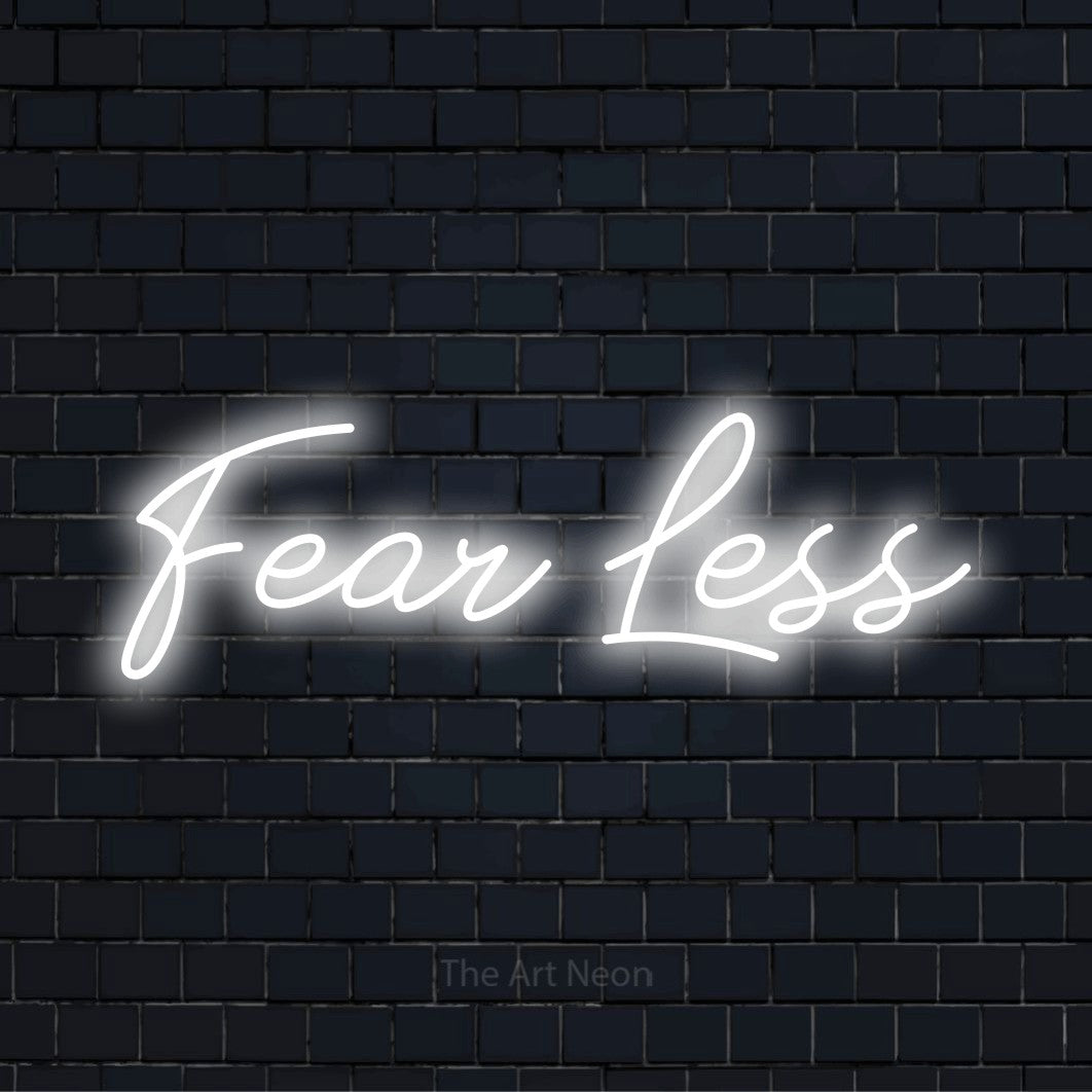 "Fear Less" script-style LED neon sign on a black brick wall