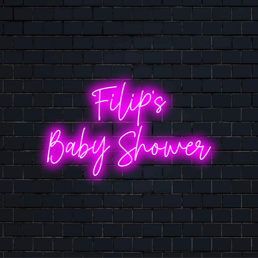 Filip_s Baby Shower Personalized LED Neon Sign, glowing lettering against black brick wall