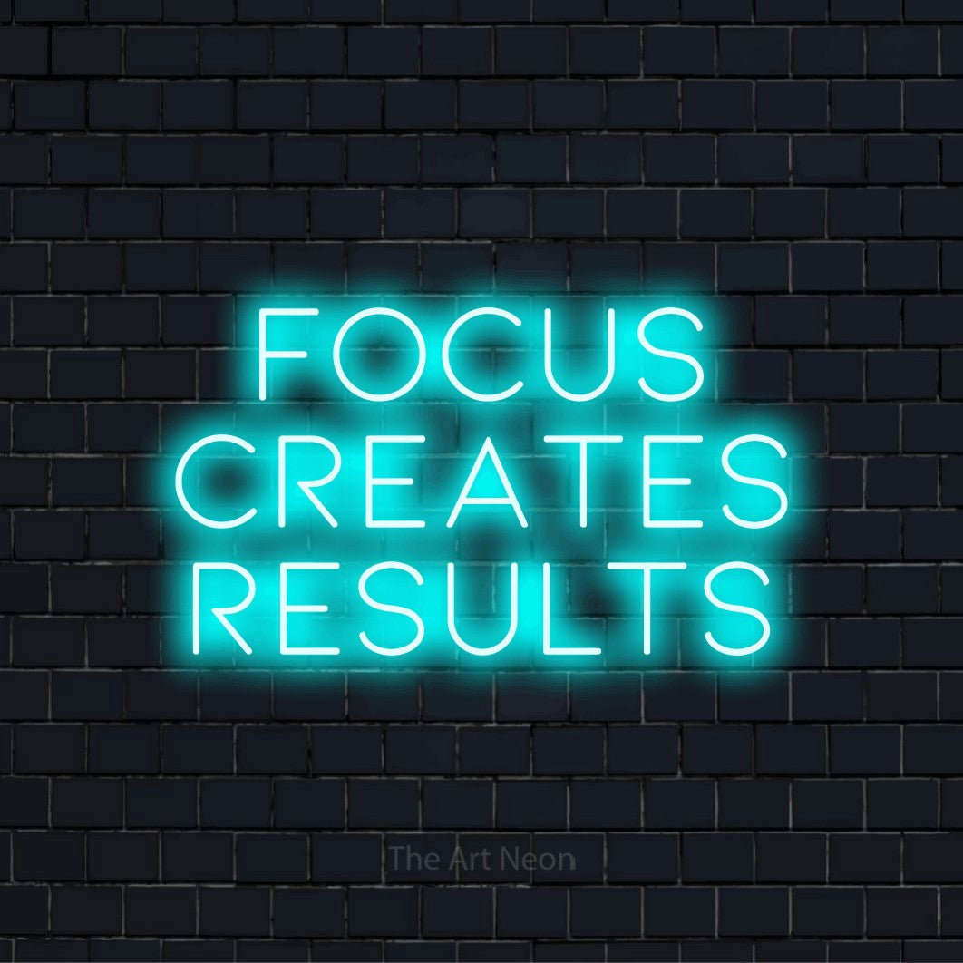 "Focus Creates Results" neon text design on a black brick wall