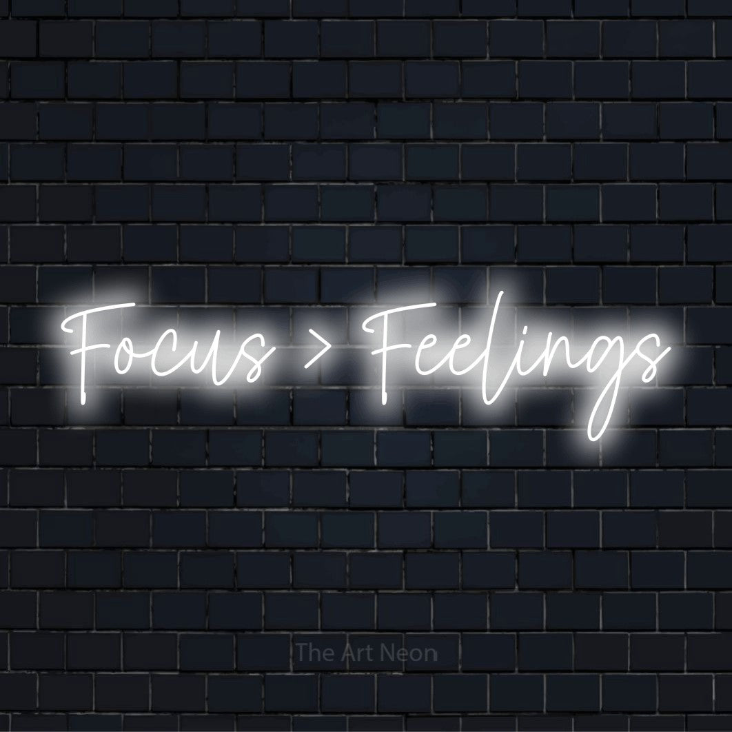 "Focus > Feelings" neon text design on a black brick wall