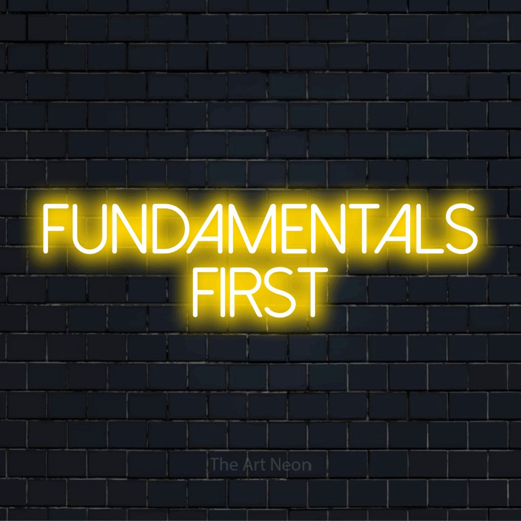 "Fundamentals First" glowing LED neon sign on a black brick wall