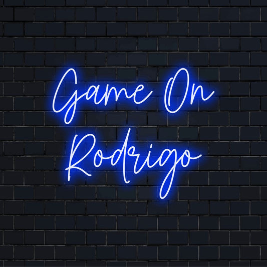 Game On Rodrigo Custom Name Neon Sign, bright neon lettering on dark brick wall
