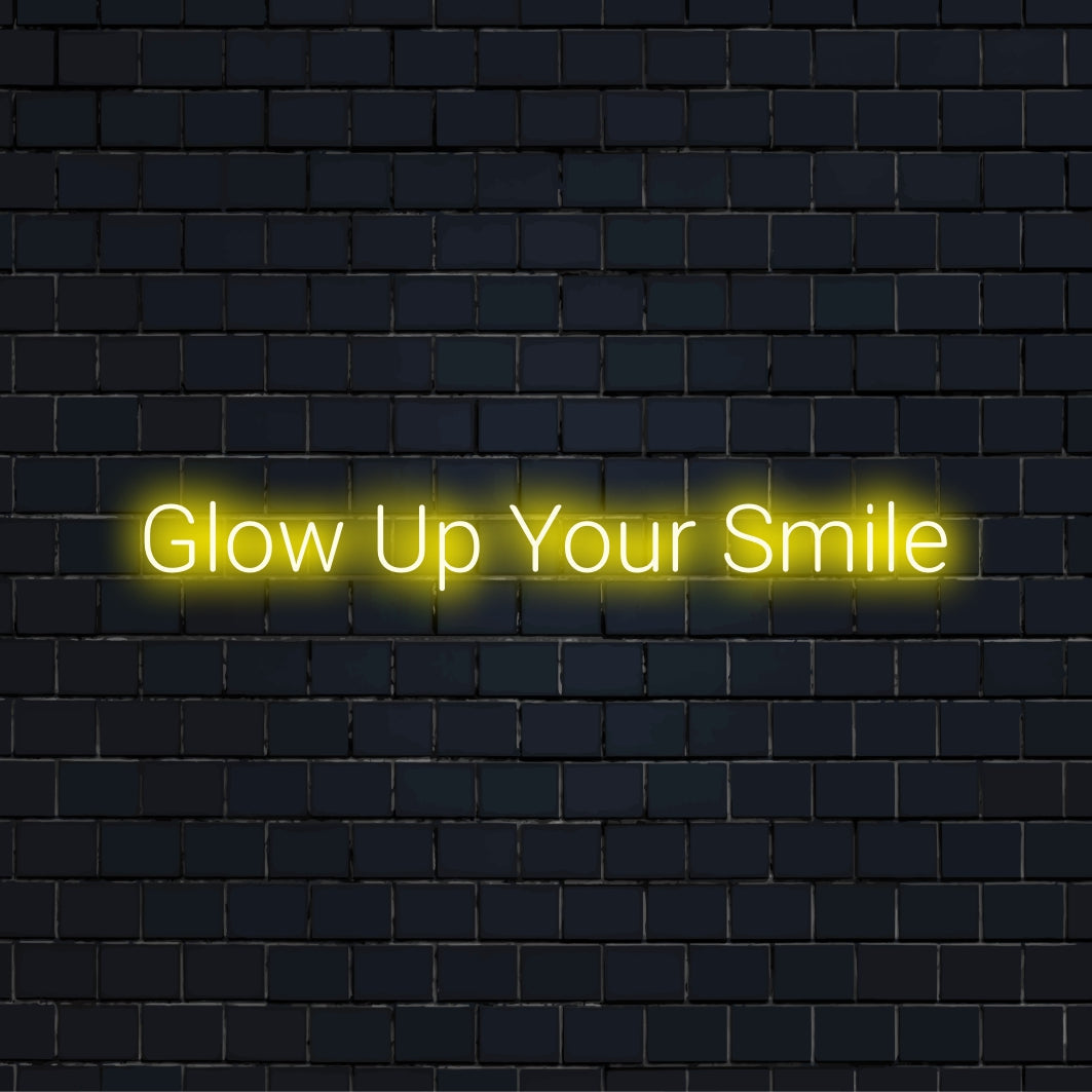 Glow Up Your Smile Neon Light with bright neon lettering on black brick background