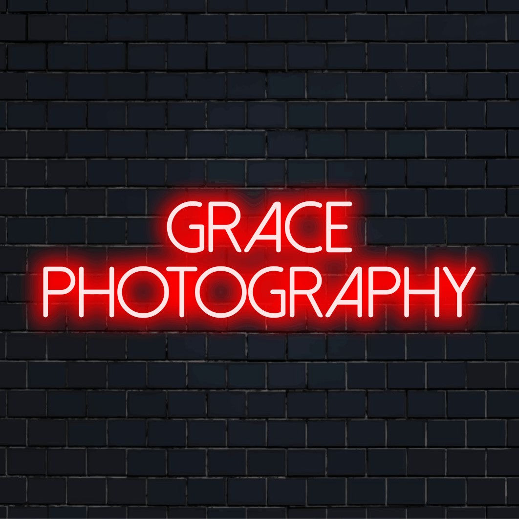 Grace Photography Custom Name Neon Sign, glowing neon text against brick backdrop
