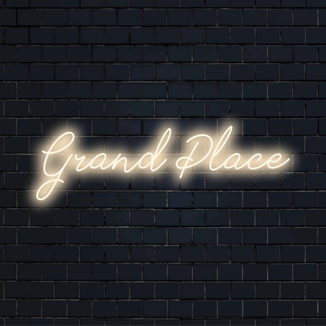 Grand Place LED Neon Sign, glowing lettering against black brick wall
