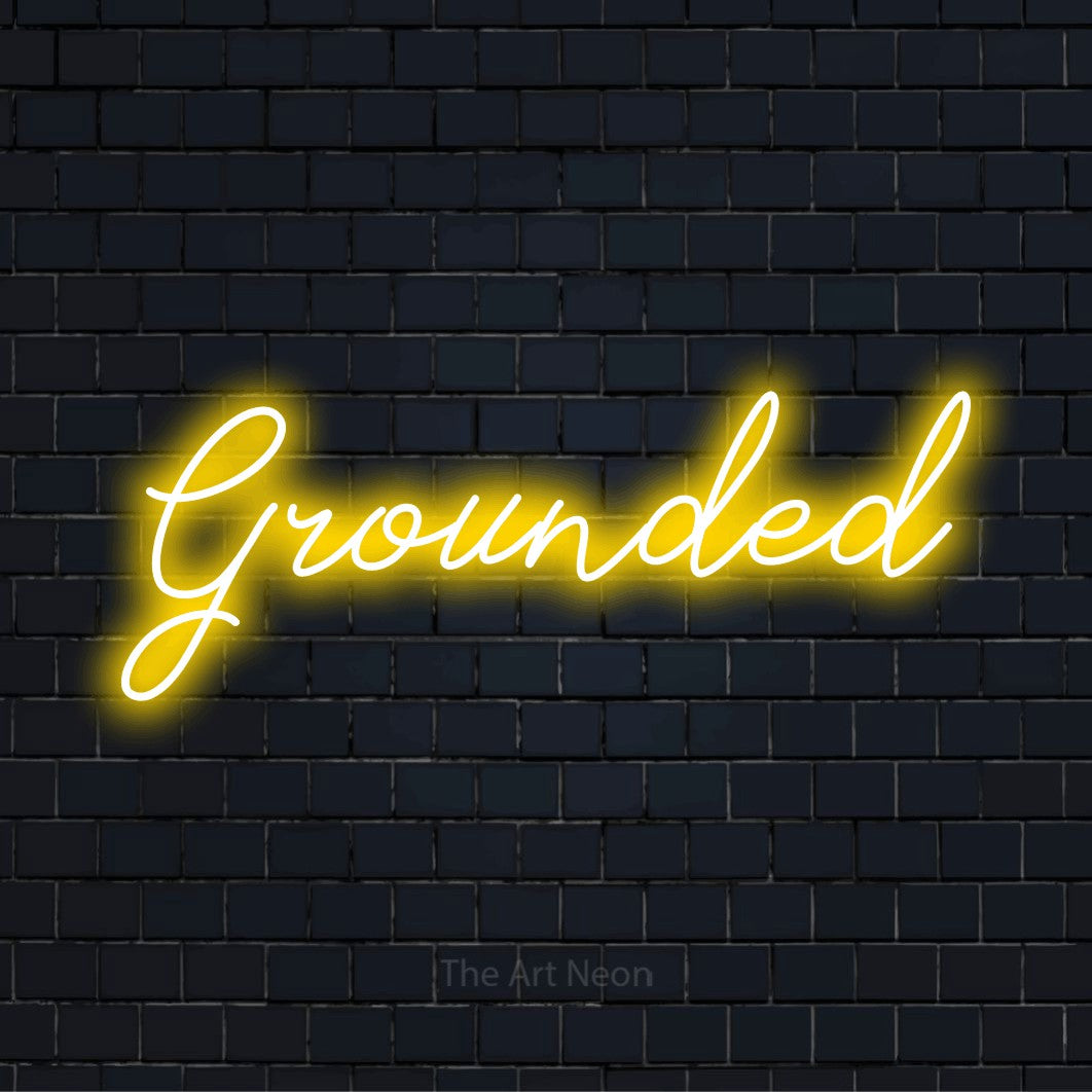 "Grounded" script-style LED neon sign on a black brick wall